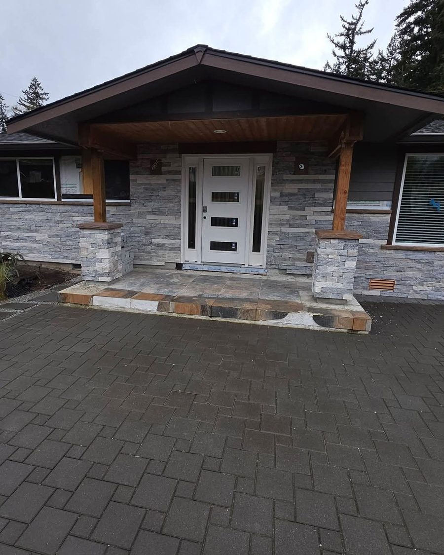 The rebuilt front entry — new stacked stone, cedar posts, tile landing and new entry door