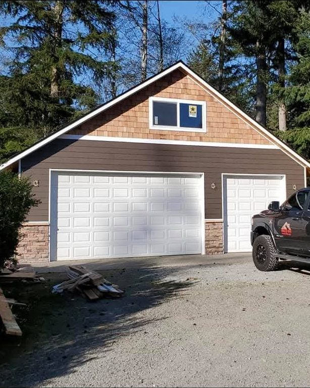 Finished detached garage with cedar-shake gable, lap siding and stone wainscot